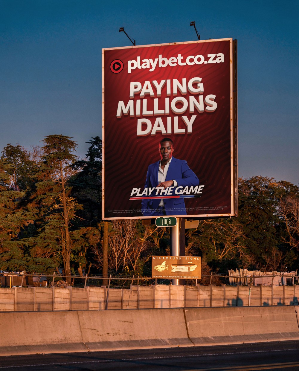 Playbet "Paying Millions Daily" billboard at dusk